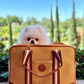 white pomeranian dog inside yellow mustard canvas carrier